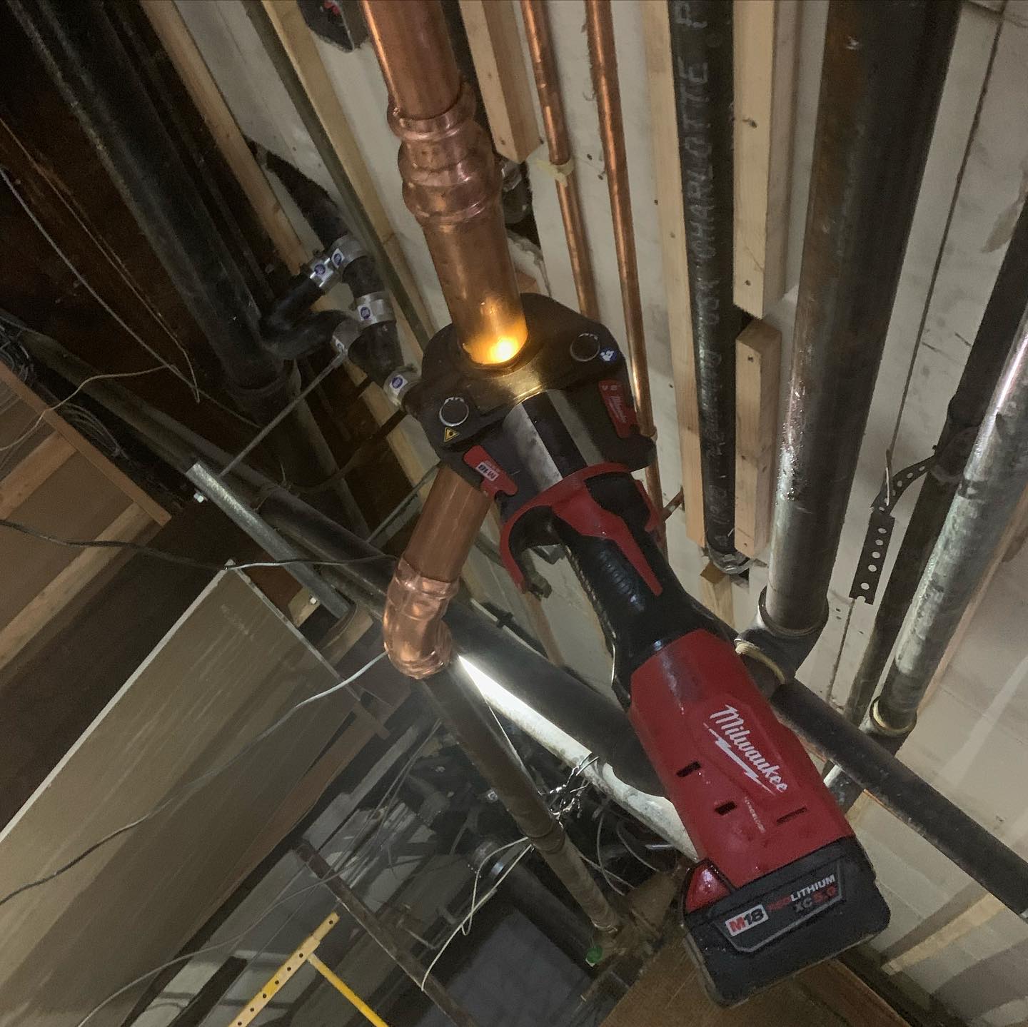 plumbers repairing a copper pipe using ProPress machine