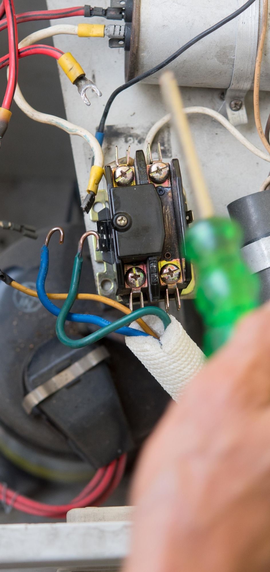 Close-up of HVAC wiring during AC repair.
