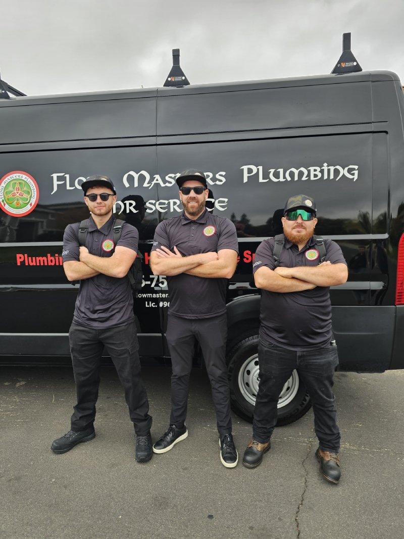 Three Flow Masters’ plumbers in front of a service truck.