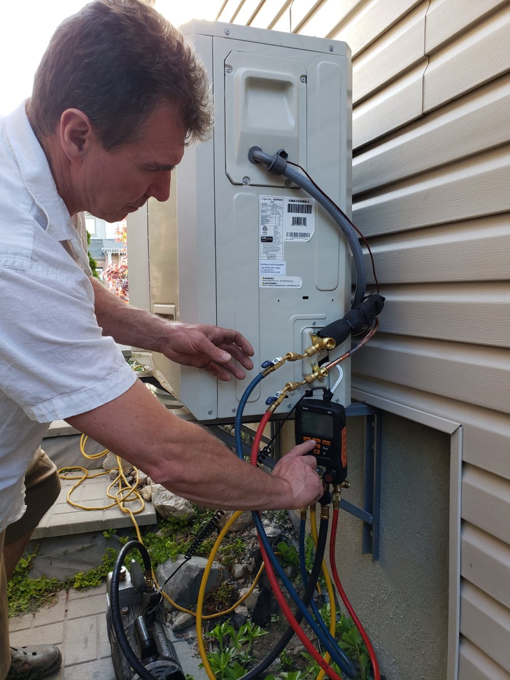 Technician testing outdoor HVAC system.