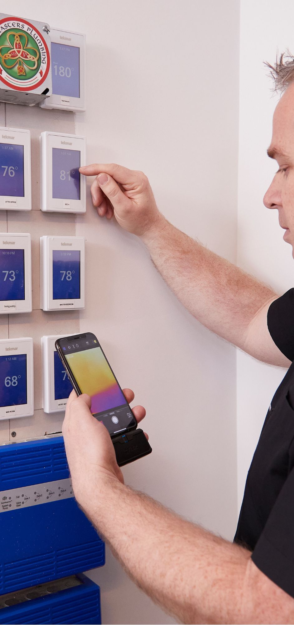 Technician configuring multiple smart thermostats.