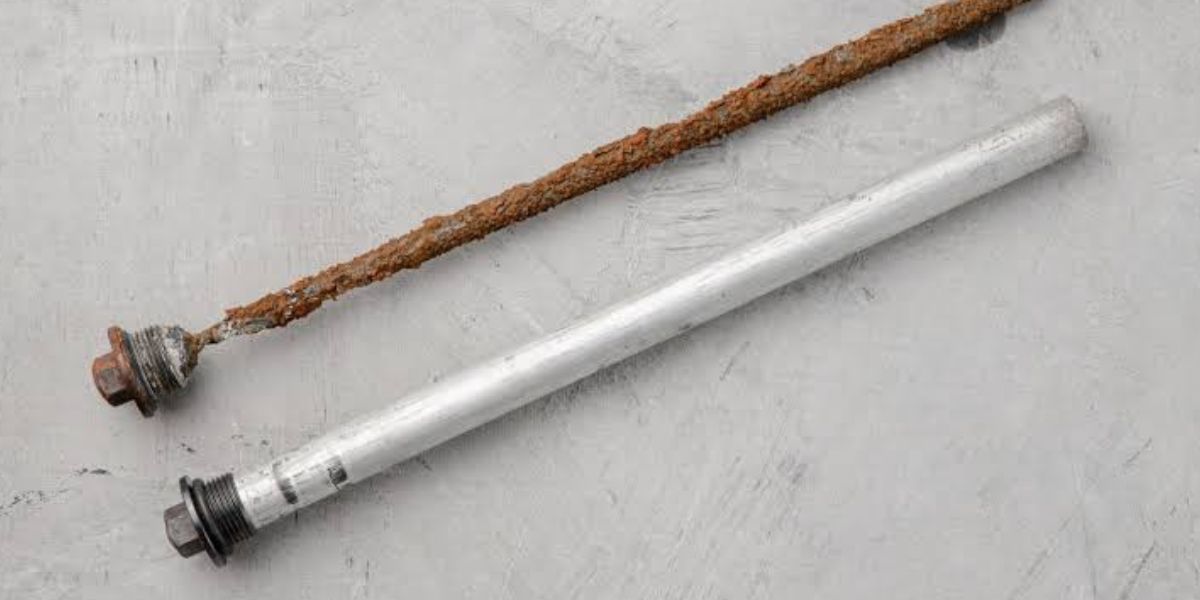 Plumber inspecting a water heater anode rod to help prevent tank corrosion and extend the life of the water heater | Water Heater Anode Rods